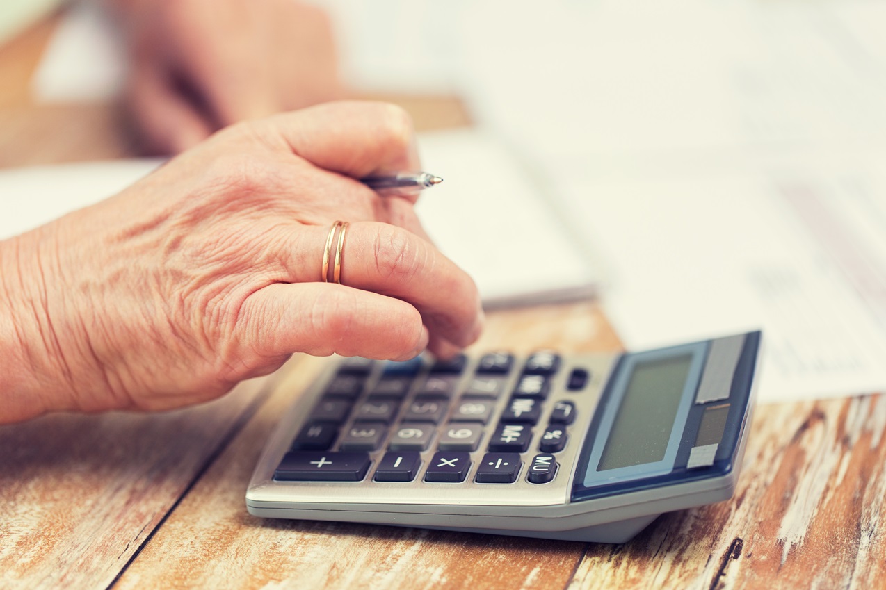 close up of senior woman counting with calculator